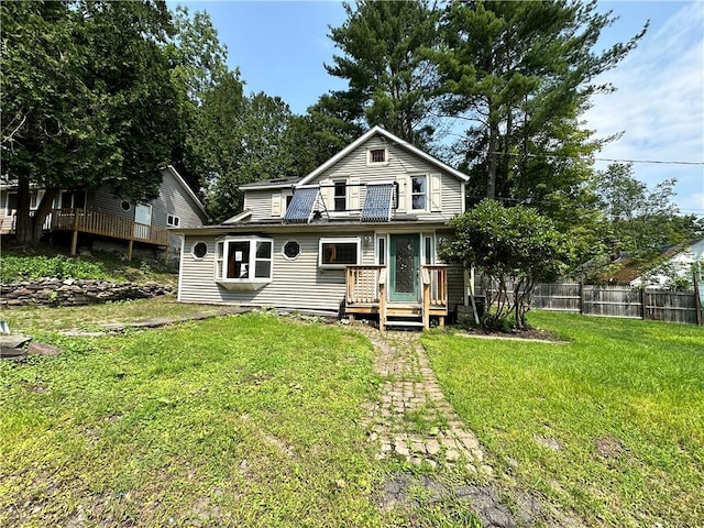 back of house with a wooden deck, fence, and a yard