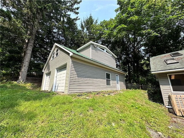 view of home's exterior featuring an attached garage and fence