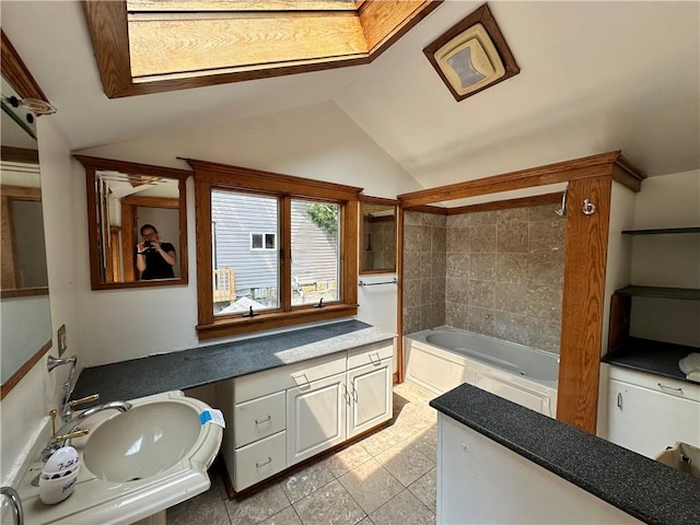 full bath featuring shower / washtub combination, tile patterned flooring, vaulted ceiling, and a sink