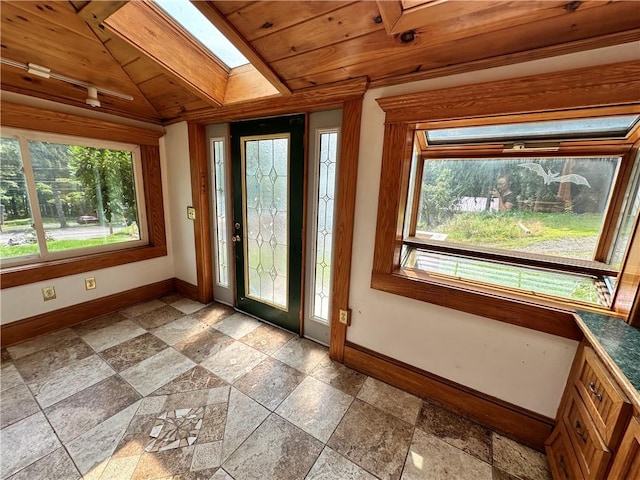 entryway featuring a skylight, plenty of natural light, baseboards, and stone tile floors