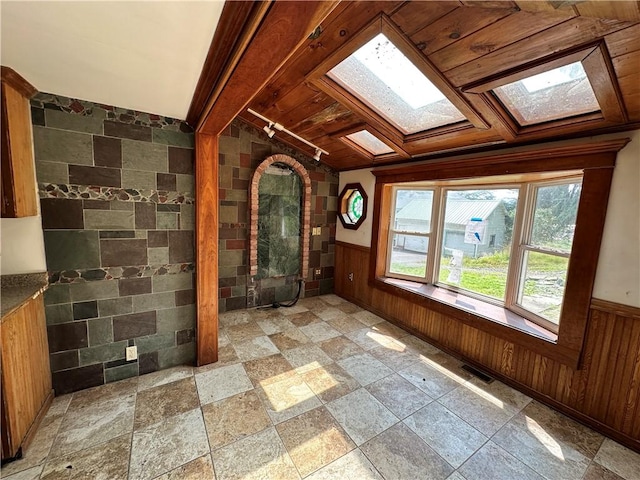 interior space featuring a skylight, beam ceiling, and visible vents