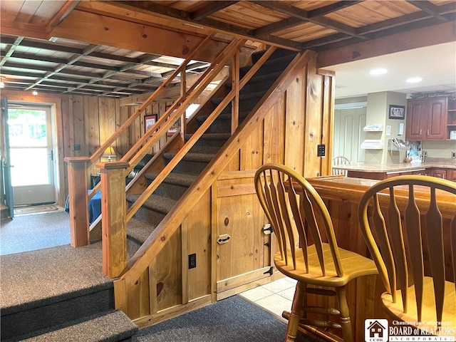 stairs with wood ceiling and wood walls