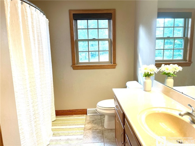 bathroom featuring vanity, tile patterned flooring, toilet, and a healthy amount of sunlight