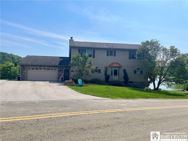 view of front of house featuring a garage and a front lawn