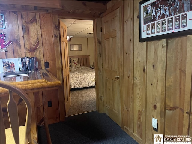 hall with wood walls and carpet flooring