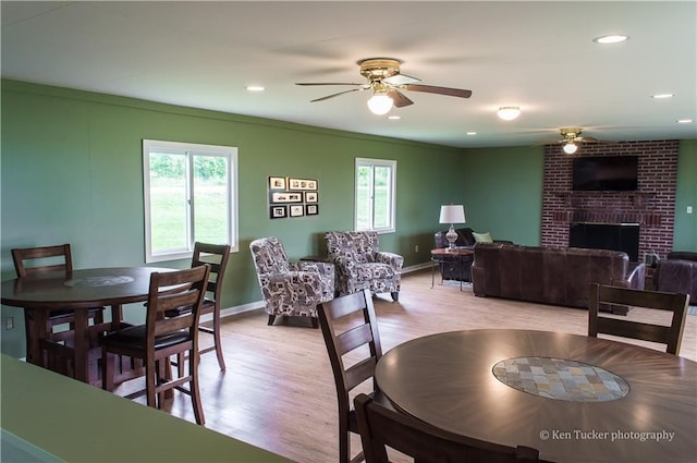 dining room with a fireplace, ceiling fan, and a wealth of natural light