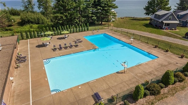 view of swimming pool with a patio and a water view