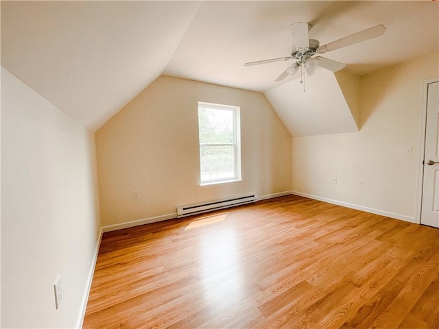 additional living space featuring ceiling fan, baseboard heating, light wood-type flooring, and vaulted ceiling