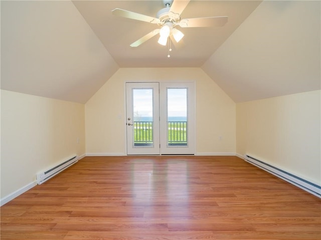 bonus room with a baseboard heating unit, lofted ceiling, light hardwood / wood-style floors, and ceiling fan