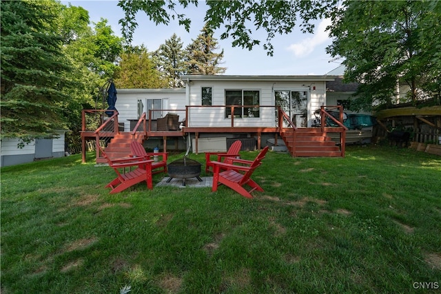 rear view of house featuring an outdoor fire pit, a yard, and a wooden deck