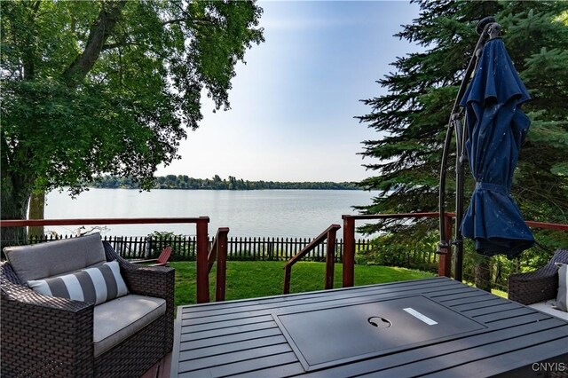 deck with a lawn and a water view