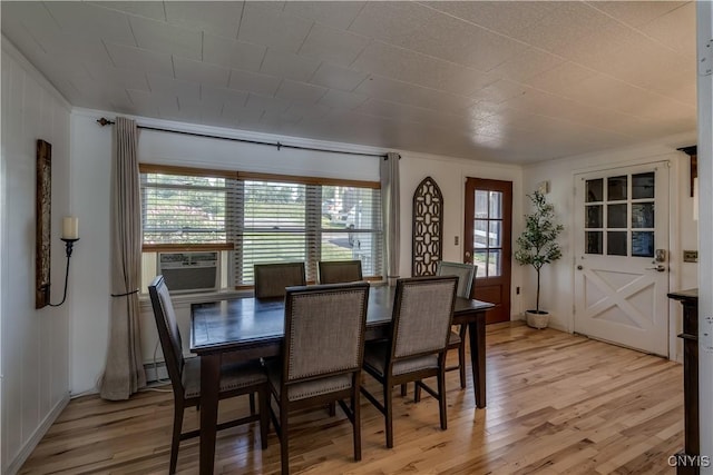 dining space featuring cooling unit, light wood finished floors, and a baseboard radiator