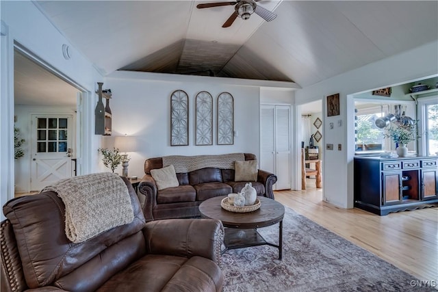 living room featuring a ceiling fan, lofted ceiling, and light wood finished floors