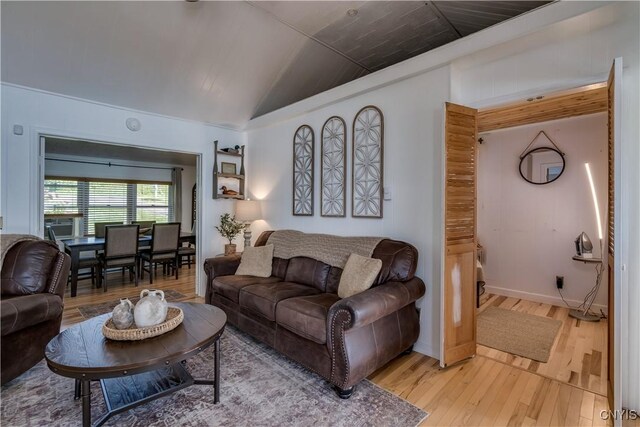 living room featuring lofted ceiling and light hardwood / wood-style flooring