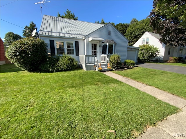 view of front of house featuring a garage, a front yard, and an outbuilding