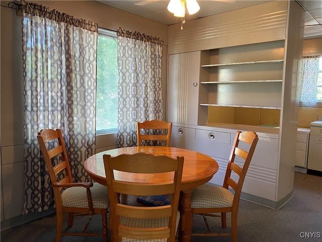 carpeted dining space featuring plenty of natural light and ceiling fan