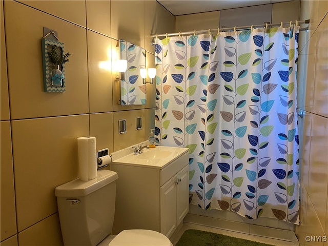 bathroom with vanity, toilet, and tile walls