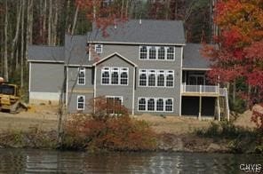 rear view of property with a balcony and a water view