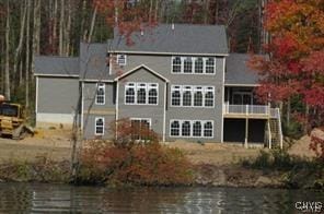 view of front of home with a water view and stairway