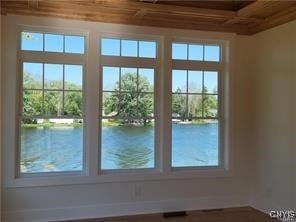 entryway featuring a water view, coffered ceiling, and wooden ceiling