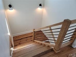 stairway featuring baseboards and wood finished floors