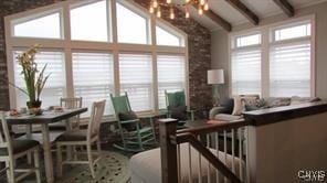 interior space featuring vaulted ceiling with beams, a wealth of natural light, and a chandelier