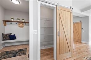 mudroom with a barn door and light wood-type flooring