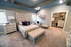 bedroom with baseboards, beam ceiling, and carpet floors