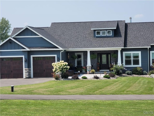 craftsman-style home featuring a garage, a front lawn, board and batten siding, driveway, and a porch