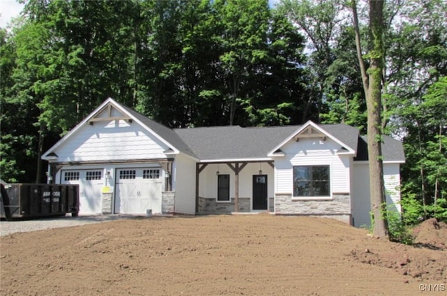 craftsman-style home featuring stone siding, driveway, and a garage