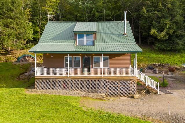 1090 Park Hill Rd, Colchester, NY 13755 - rear view of house with a porch, a forest view, metal roof, and stairs
