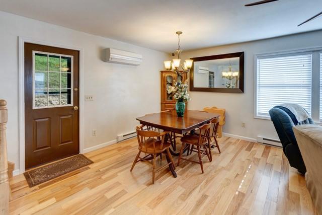 1090 Park Hill Rd, Colchester, NY 13755 - dining space with a baseboard heating unit, a wall mounted AC, plenty of natural light, and light wood finished floors