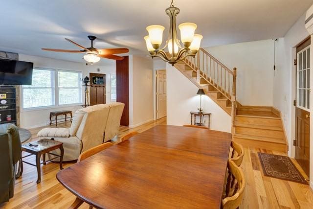 1090 Park Hill Rd, Colchester, NY 13755 - dining area with light wood finished floors, a wall mounted air conditioner, ceiling fan with notable chandelier, baseboards, and stairway