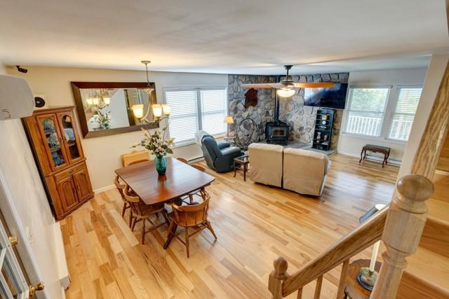 1090 Park Hill Rd, Colchester, NY 13755 - dining area featuring plenty of natural light, a wood stove, and light wood-type flooring