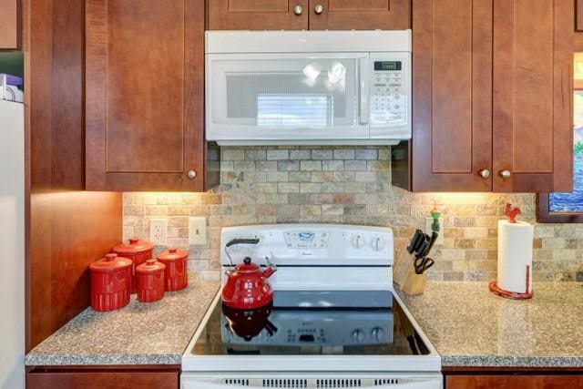 1090 Park Hill Rd, Colchester, NY 13755 - kitchen with white appliances, brown cabinetry, and tasteful backsplash