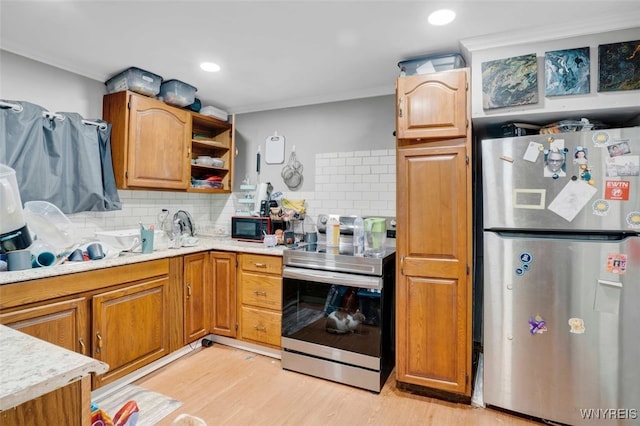 kitchen featuring tasteful backsplash, appliances with stainless steel finishes, and light hardwood / wood-style floors