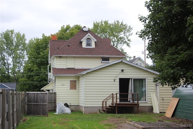 rear view of house featuring a yard