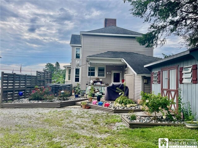 rear view of property with a hot tub