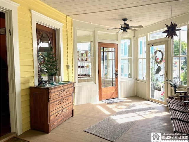 sunroom / solarium with ceiling fan, wooden ceiling, and a healthy amount of sunlight