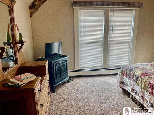 carpeted bedroom featuring baseboard heating