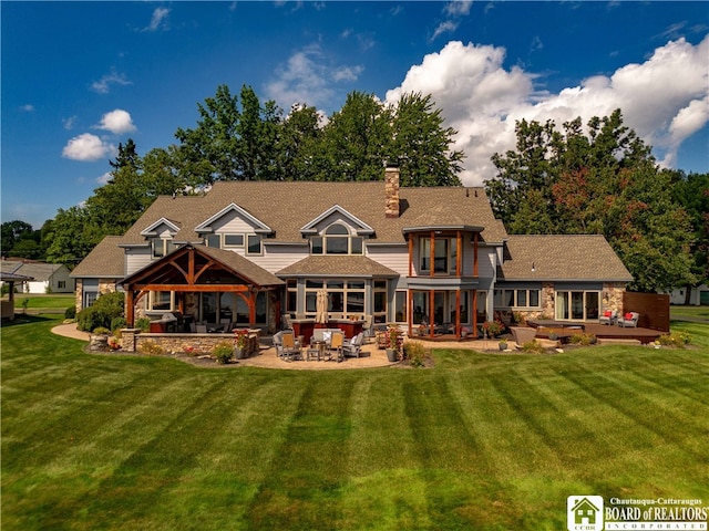 rear view of property with a yard, a patio, and a gazebo