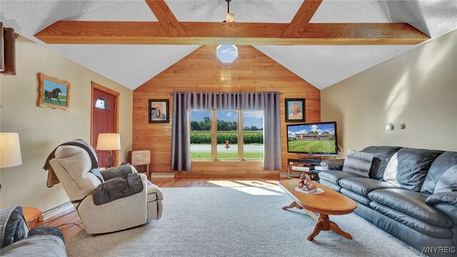 living room with baseboard heating, light hardwood / wood-style floors, vaulted ceiling with beams, wood walls, and a textured ceiling