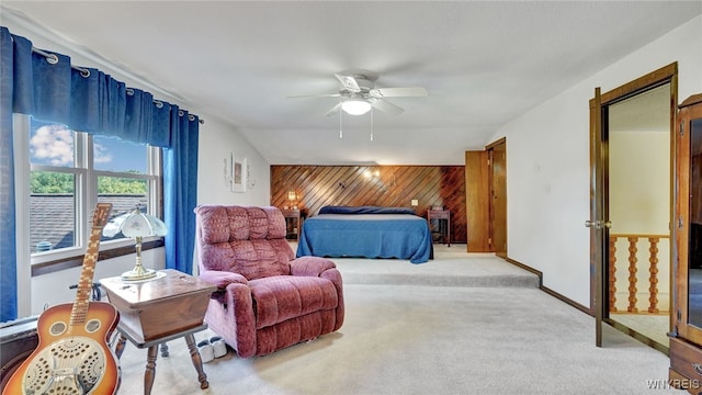 carpeted bedroom featuring ceiling fan, wood walls, and vaulted ceiling