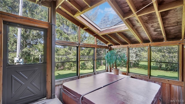 unfurnished sunroom with lofted ceiling with skylight