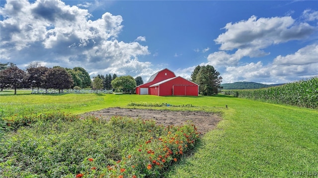 view of yard featuring an outdoor structure, a mountain view, and a rural view