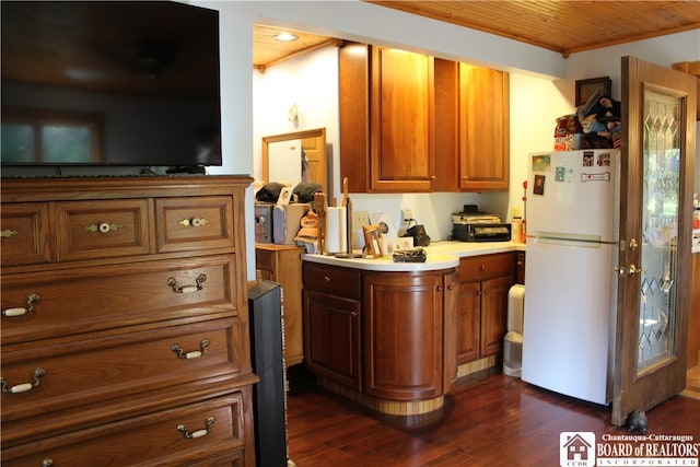 kitchen with ornamental molding, white refrigerator, and dark hardwood / wood-style floors