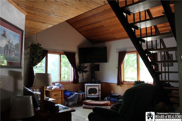 living room with lofted ceiling, wooden walls, and wooden ceiling