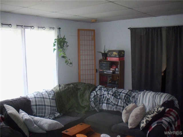 living room with a wealth of natural light and a drop ceiling