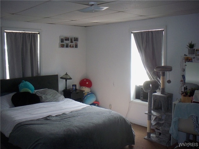 bedroom with carpet flooring and a drop ceiling