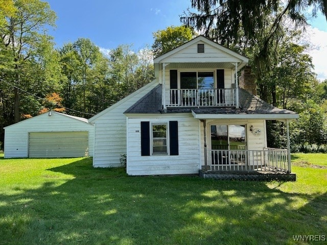 back of property with a garage, an outdoor structure, and a lawn